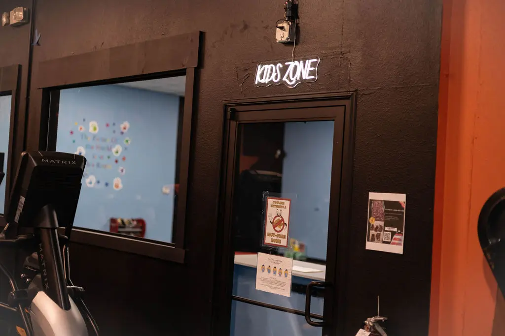 Kids Zone entrance with neon sign at TX Fitness Forney gym with childcare