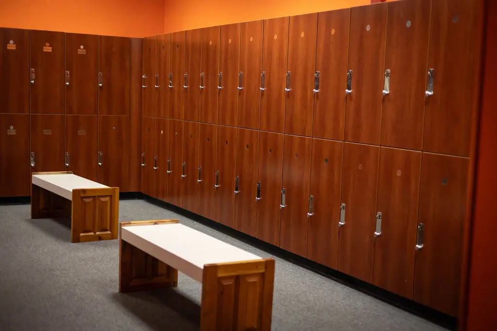 Clean locker room with wooden lockers and benches at TX Fitness Forney